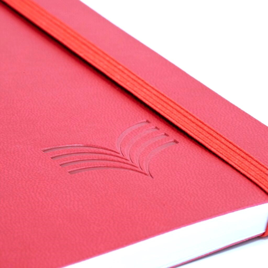 Close-up of a red notebook with a logo on a white background